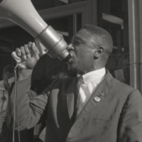 Harold Brown speaking into a megaphone, 1964