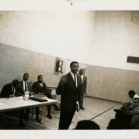 Harold Brown speaking to audience in gymnasium