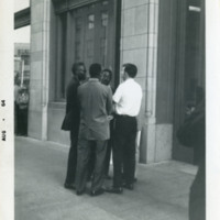 Four men standing close together, 1964